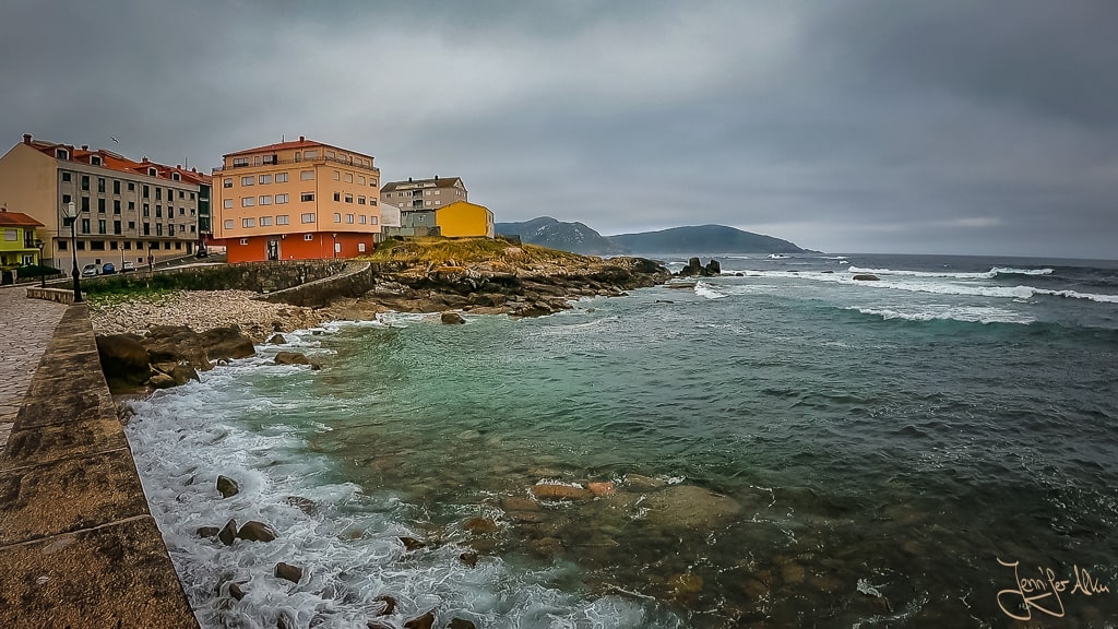 Praia do Coido in Muxia bei Flut mit unruhigem Wasser und zugezogenem Himmel an der Costa da Morte.