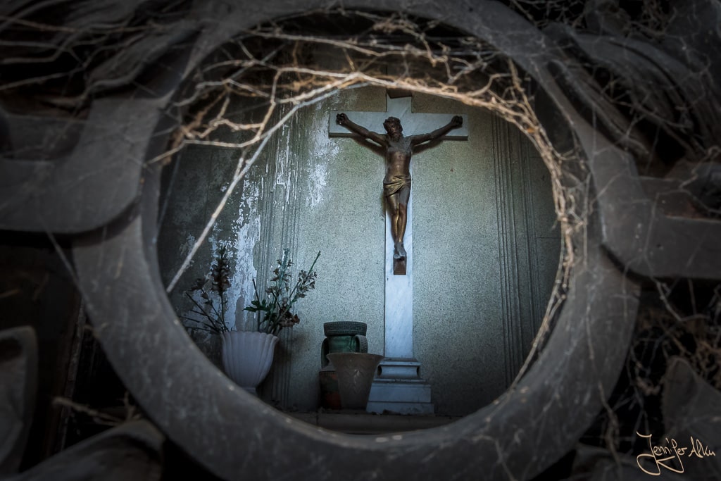 Dieses Bild zeigt Jesus am Kreuz beim Blick in ein Mausoleum auf dem Friedhof Cementerio de la Recoleta in Buenos Aires