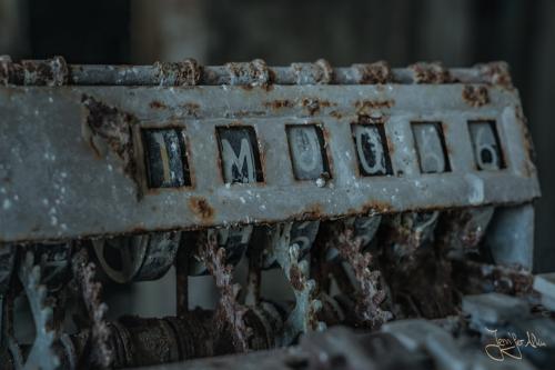 Detailaufnahme einer verrosteten Kasse in der verlassenen Schule