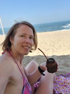 Dieses Bild zeigt Jennifer Alka beim Mate trinken am Strand