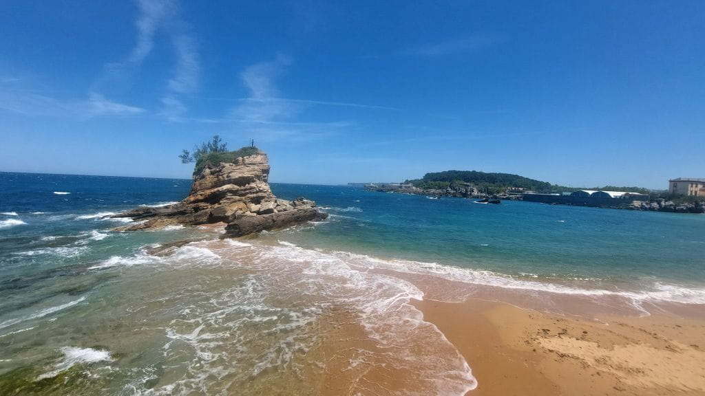 Strand mit Felsformationen und Wellen am Camino del Norte an der spanischen Küste