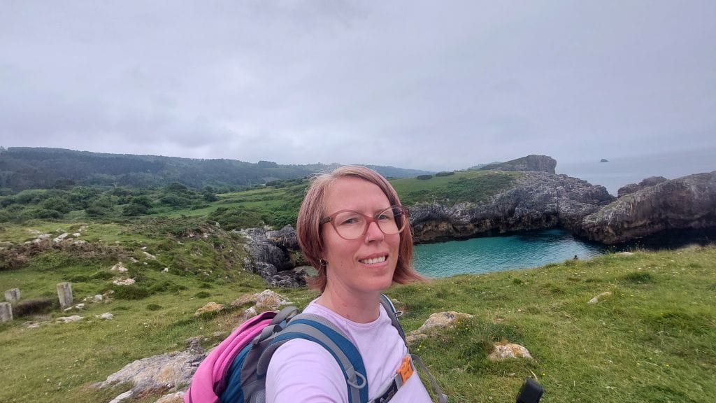 Jennifer Alka auf dem Camino del Norte mit beeindruckenden Felsformationen im Hintergrund