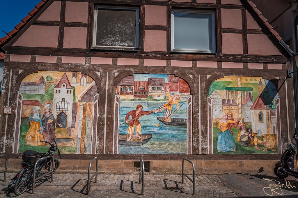 Dieses Bild zeigt die Gemälde an dem Fachwerkhaus in der Sanstraße, dass die Geschichte von Bamberg erzählt.