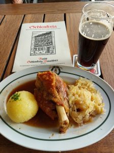 Dieses Bild zeigt Fränkisches Essen in Bamberg beim Schlenkerla - Haxen mit Dunkelbiersauce, Kloß und Sauerkraut