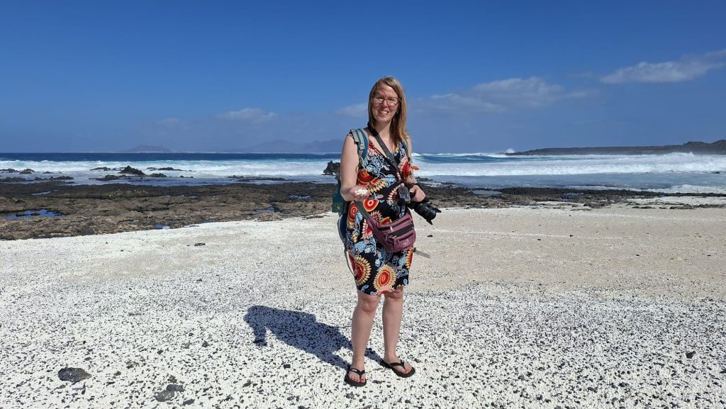 Jennifer Alka steht am PopcornStrand auf Fuerteventura und hält Rhodolithen in der Hand