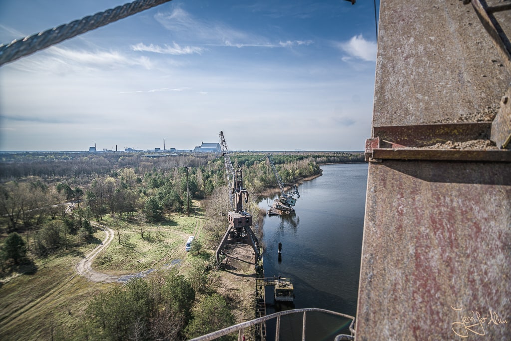 Dieses Bild ist auf den Kränen von Pripyat entstanden. Es zeigt die rostigen Kräne und das Sarkophag des Atomkraftwerks von Tschernobyl