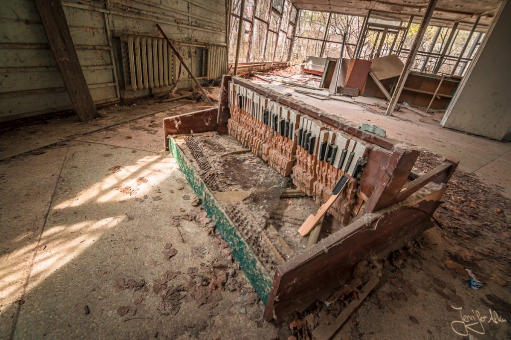 Dieses Bild zeigt ein kaputtes Klavier, das auf dem Boden liegt. Tschernobyl / Ukraine