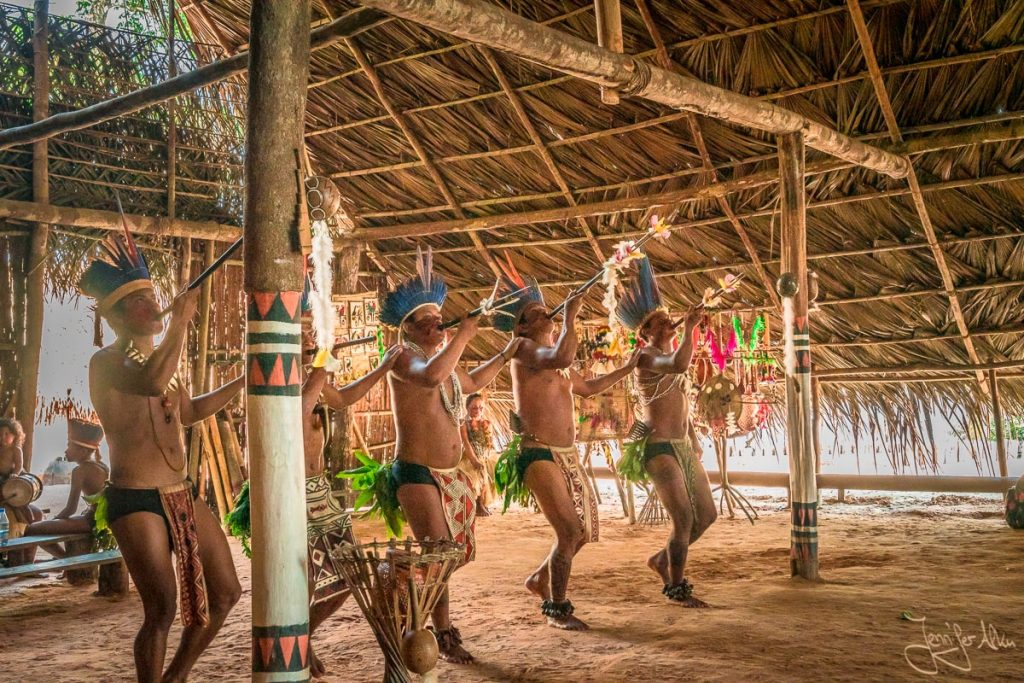 Dieses Bild zeigt das indigene Volk im Amazonas Regenwald. Sie machen Musik für uns und tanzen.