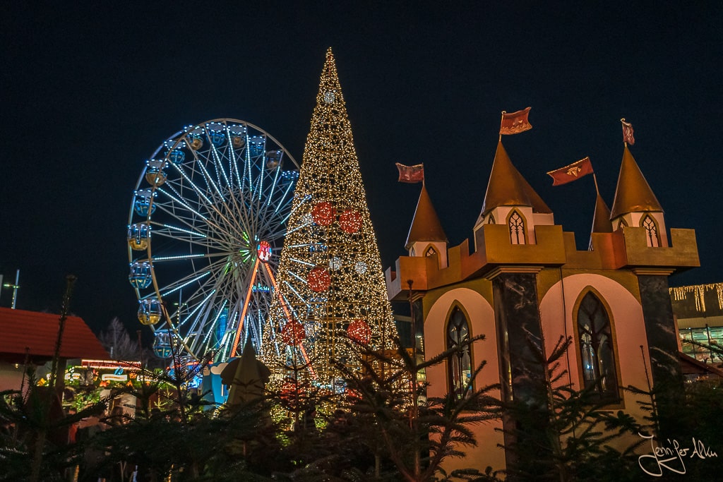 Dieses Bild zeig den Weihnachtsmarkt Leipzig 2023. Du siehst den Weihnachtsbaum, das Märchenschloss und das Riesenrad auf dem Leipziger Augustusplatz